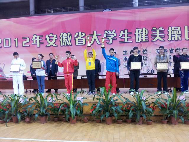 图中着黄衣者为滁州学院体育学院王小双正领取团体总分第一奖杯